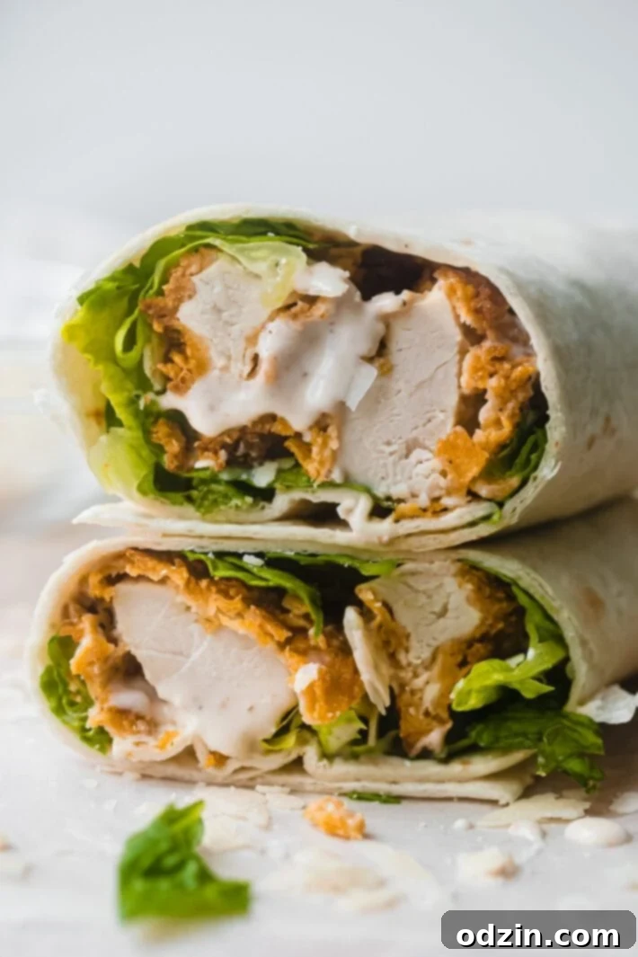 Caesar Crunch Chicken Wraps 3 A delicious sliced chicken caesar wrap revealing crispy chicken, fresh lettuce, shaved parmesan, and creamy Caesar dressing.