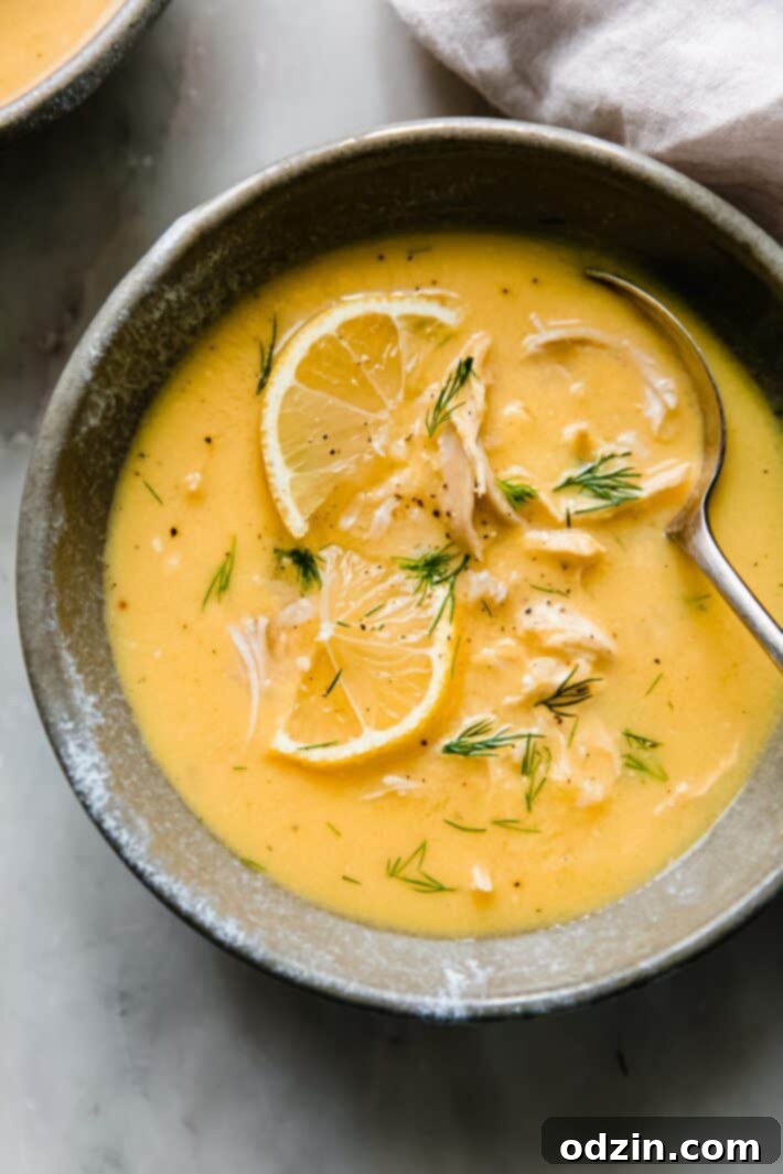 avgolemono in bowl topped with fresh lemon slices and dill