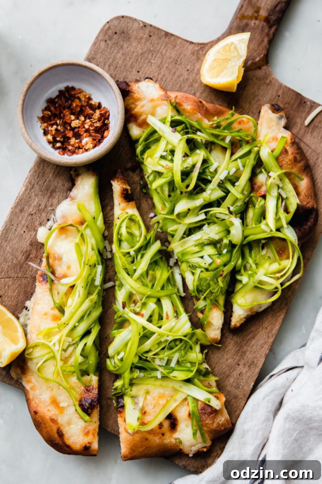 shaved asparagus pizza on wooden board