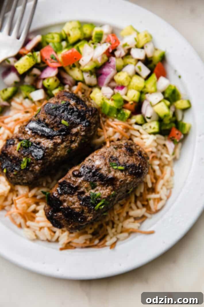 Lebanese rice, kafta kabob, and Shirazi salad in plate with fork