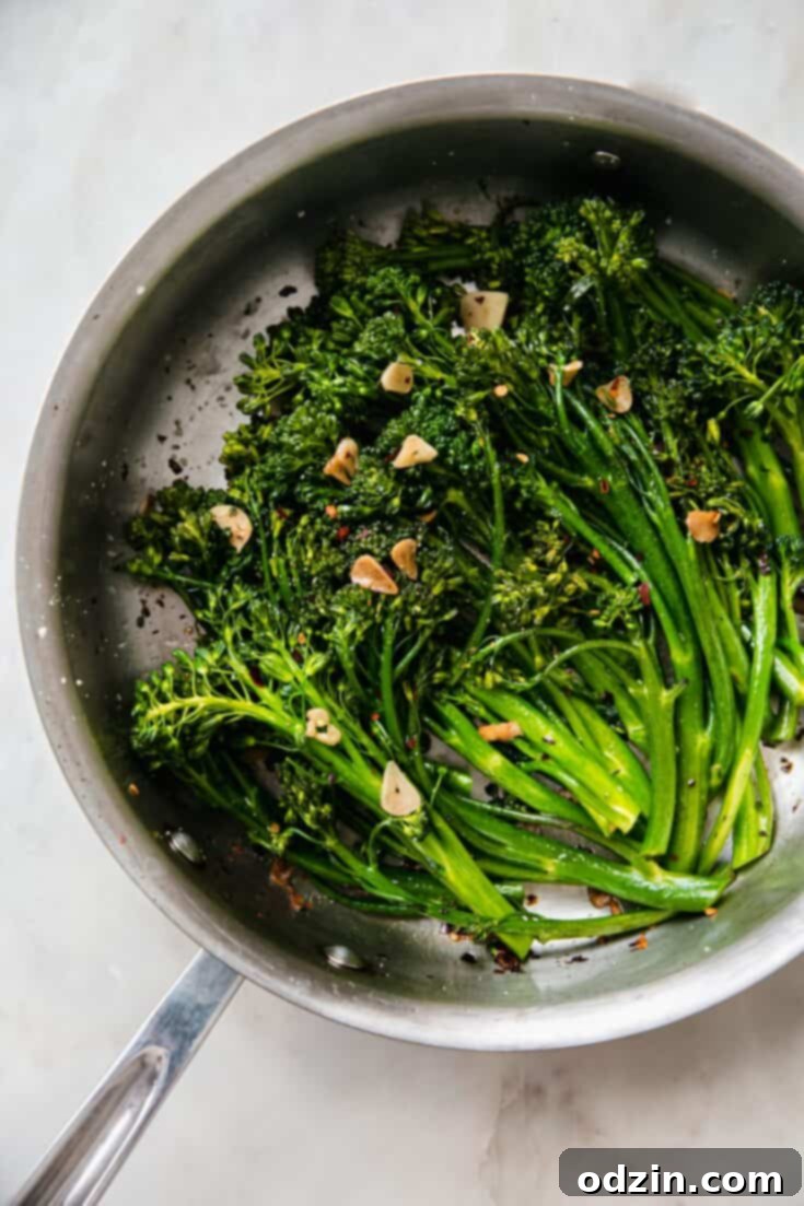 Garlic Sautéed Broccolini, a vibrant green side dish, garnished with crispy garlic chips and a hint of red pepper flakes.