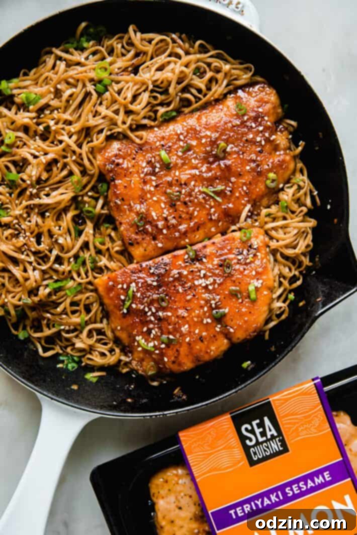 Sticky Teriyaki Salmon with Ginger Noodles 5 A cast iron skillet containing ginger noodles, a cooked Teriyaki Sesame Salmon fillet, and a package of Sea Cuisine Teriyaki Sesame Salmon.