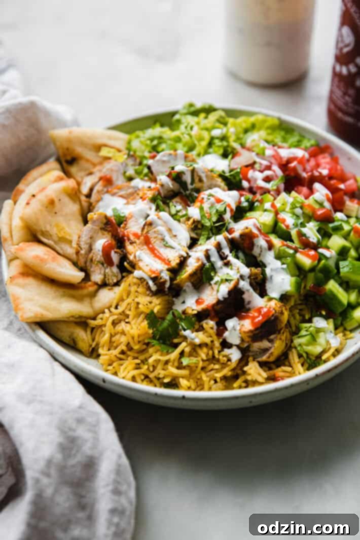 chicken over rice with veggies and sauces