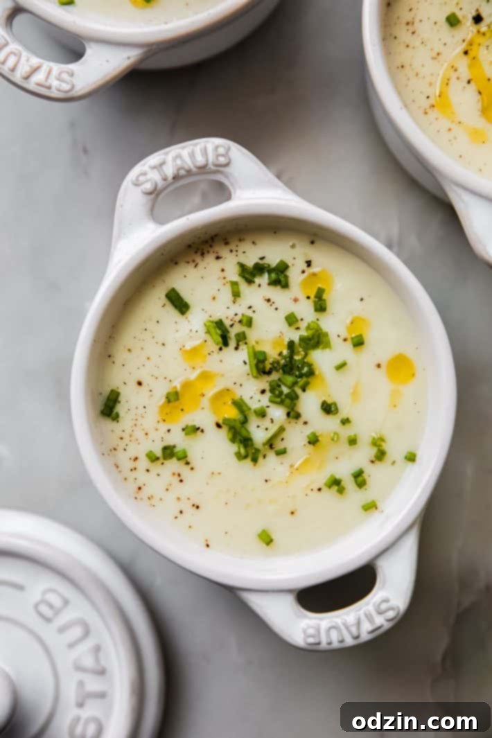 Velvety Roasted Garlic Potato Soup with Crispy Grilled Cheese Croutons 6 small dish of soup topped with chives, black pepper, and olive oil