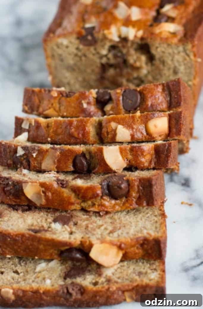 A generous slice of Coconut Chocolate Chip Banana Bread, ready to be enjoyed with a hot beverage. #breakfastideas #snacktime
