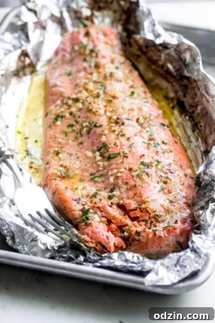 large salmon filet on foil on baking sheet pan