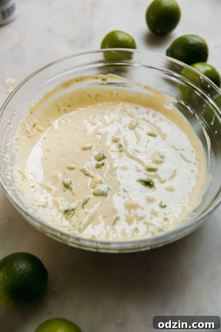 Bowl of creamy key lime pie filling with whisk