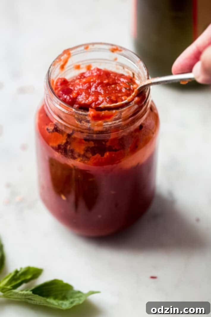 Pizza Sauce in a Jar with a Spoon close up of pizza sauce in a jar with a spoon