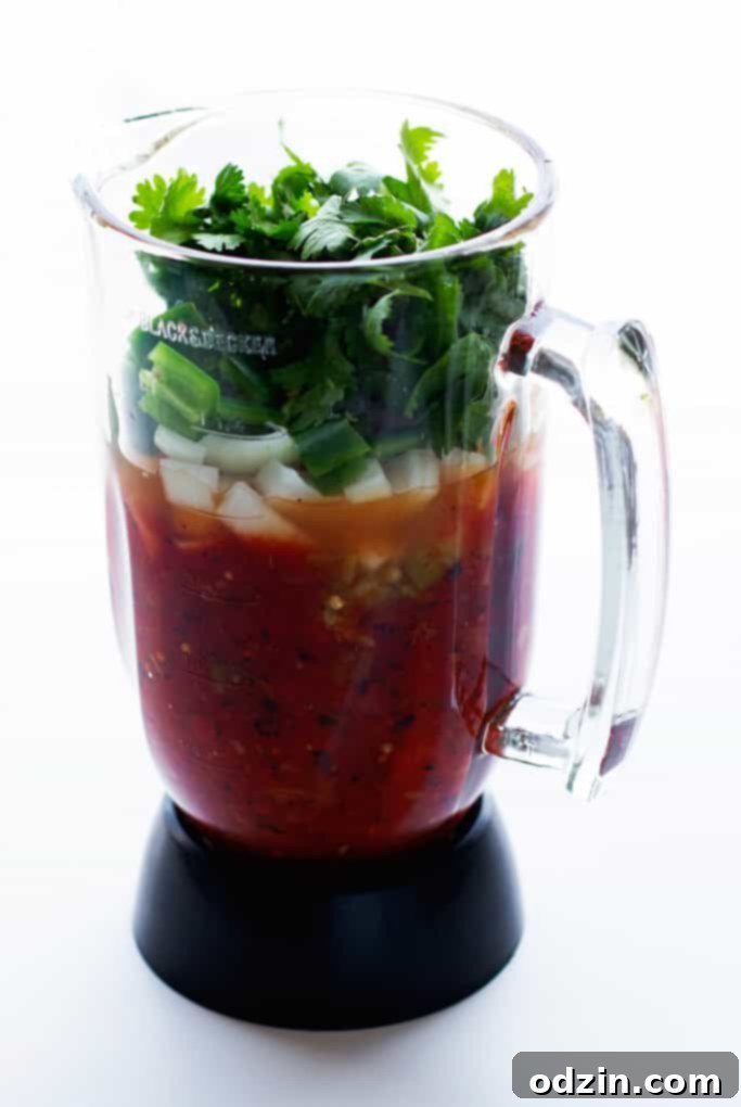 blender with all the ingredients for blender salsa before blending