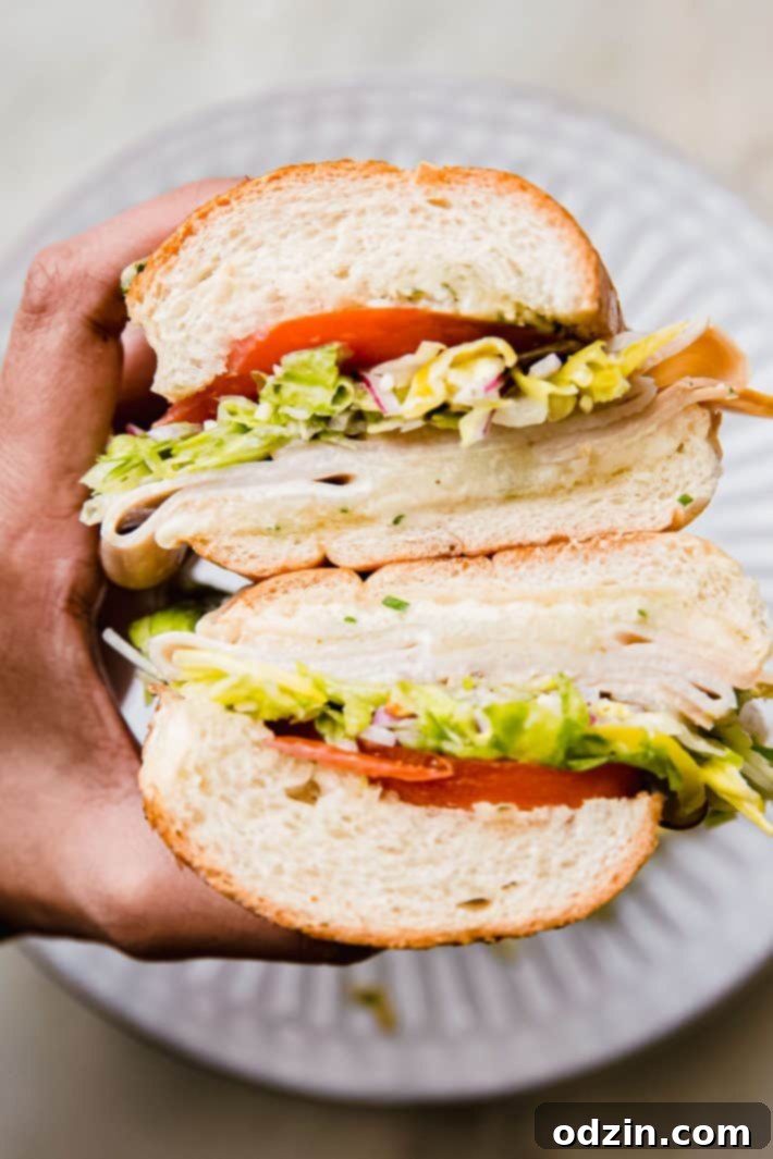 Italian sandwich in hand over plate
