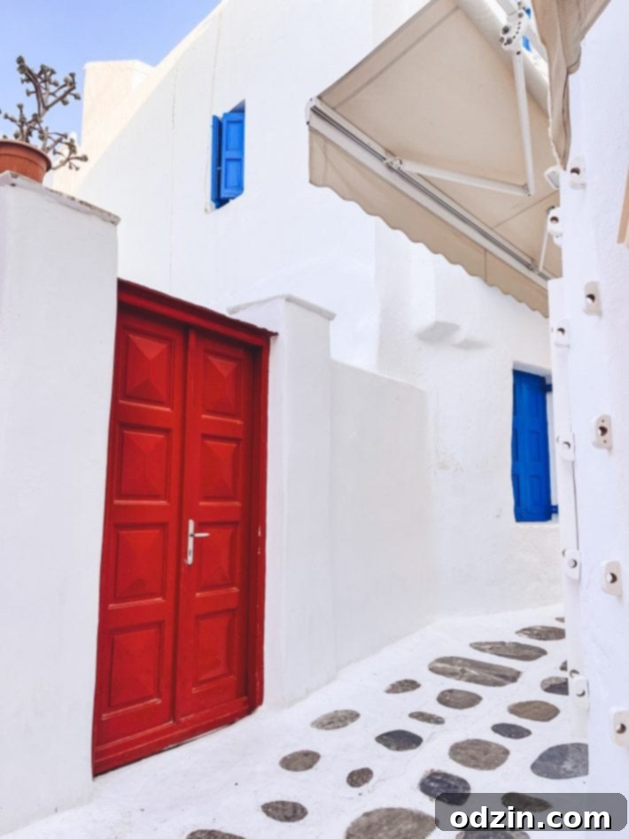 A charming street in Mykonos Town with a red door and white-washed buildings