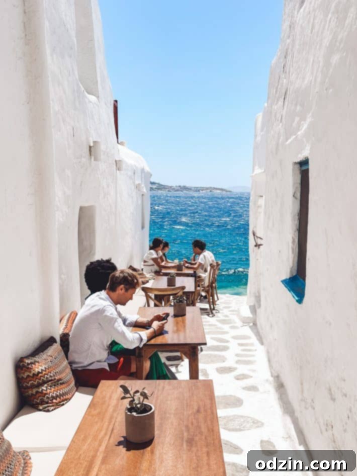 Iconic white-washed alleyway with blue accents outside Kastros Restaurant in Mykonos