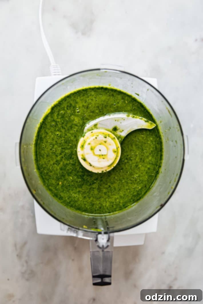 Vibrant Fresh Herb Dressing and Marinade 5 Freshly blended herb vinaigrette in a clear glass bottle, with herbs in the foreground
