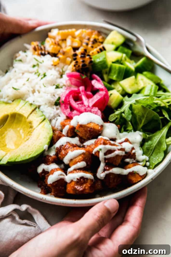 Vibrant Honey Harissa Chicken Bowls with Cooling Feta Mint 3 Feta mint sauce on harissa chicken in bowl with toppings