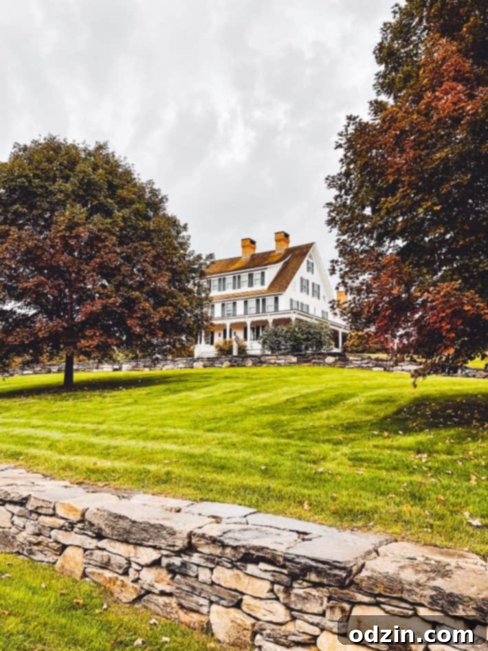 Traditional New England house on a vibrant green hill