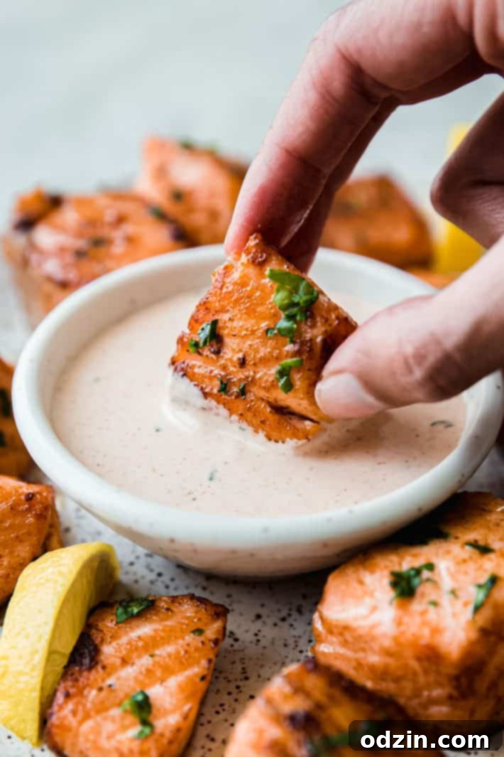 dipping air fryer salmon bites in remoulade sauce