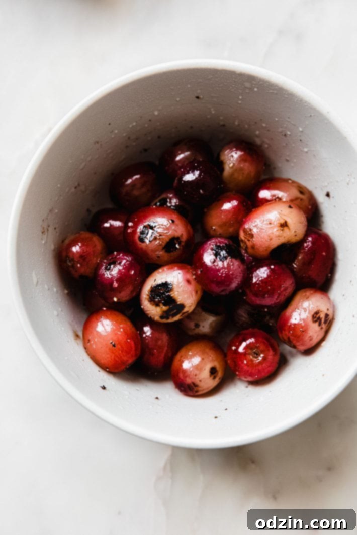 charred grapes with kosher salt and pepper in bowl