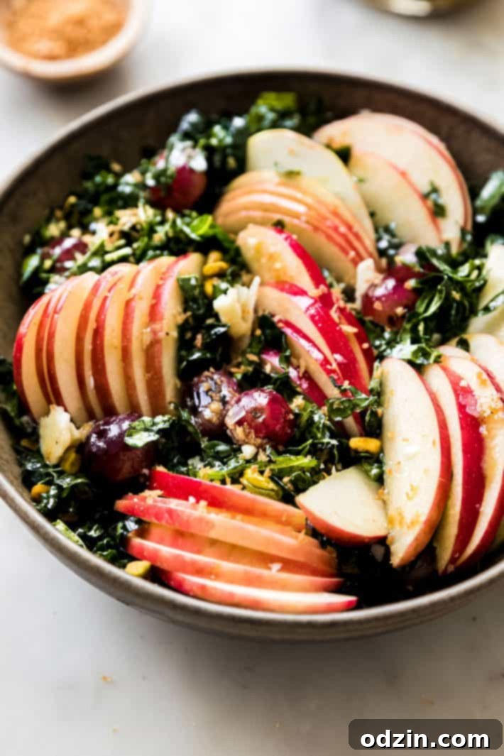 lacinato kale salad with honeycrisp apples and charred grapes in bowl