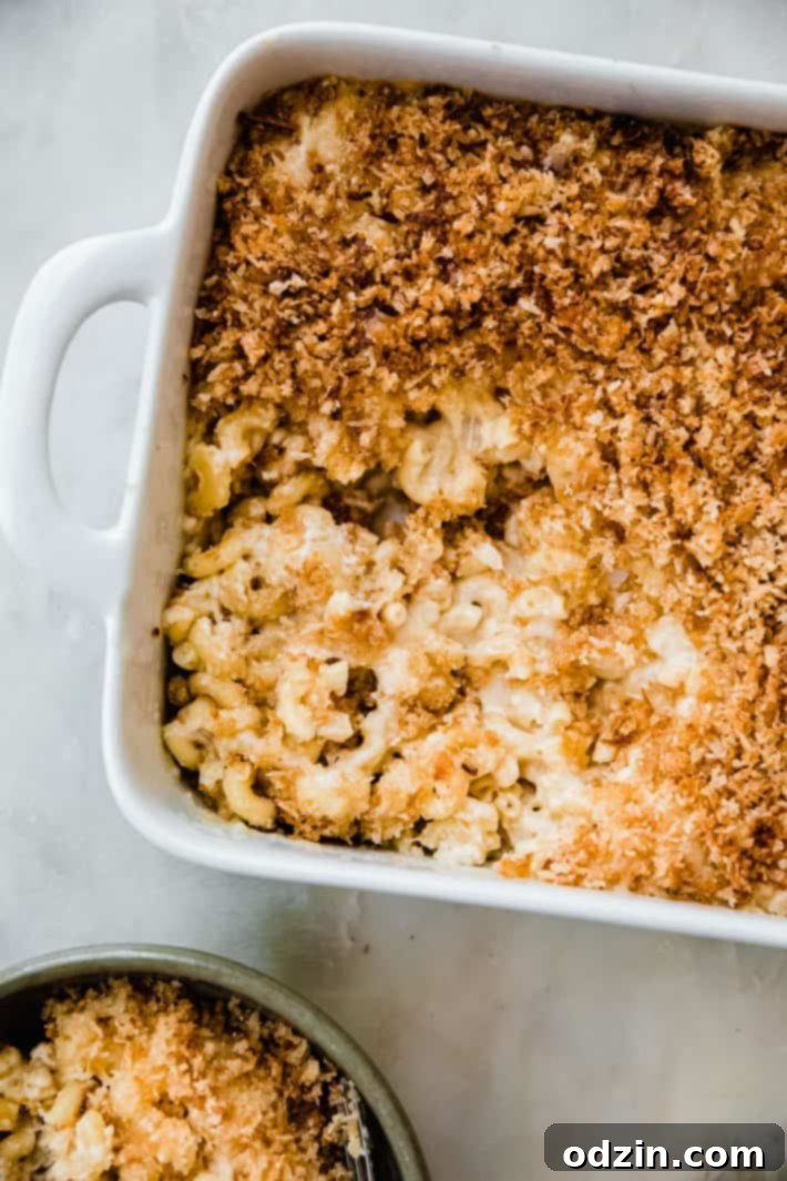 gruyere Mac and cheese with a piece missing in casserole dish