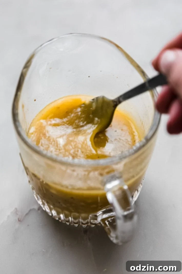 lemon shallot dressing in pitcher with fork