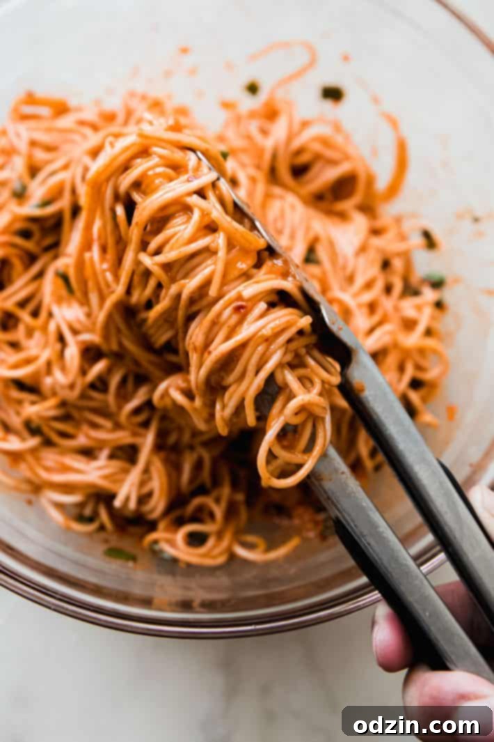 tongs holding noodles