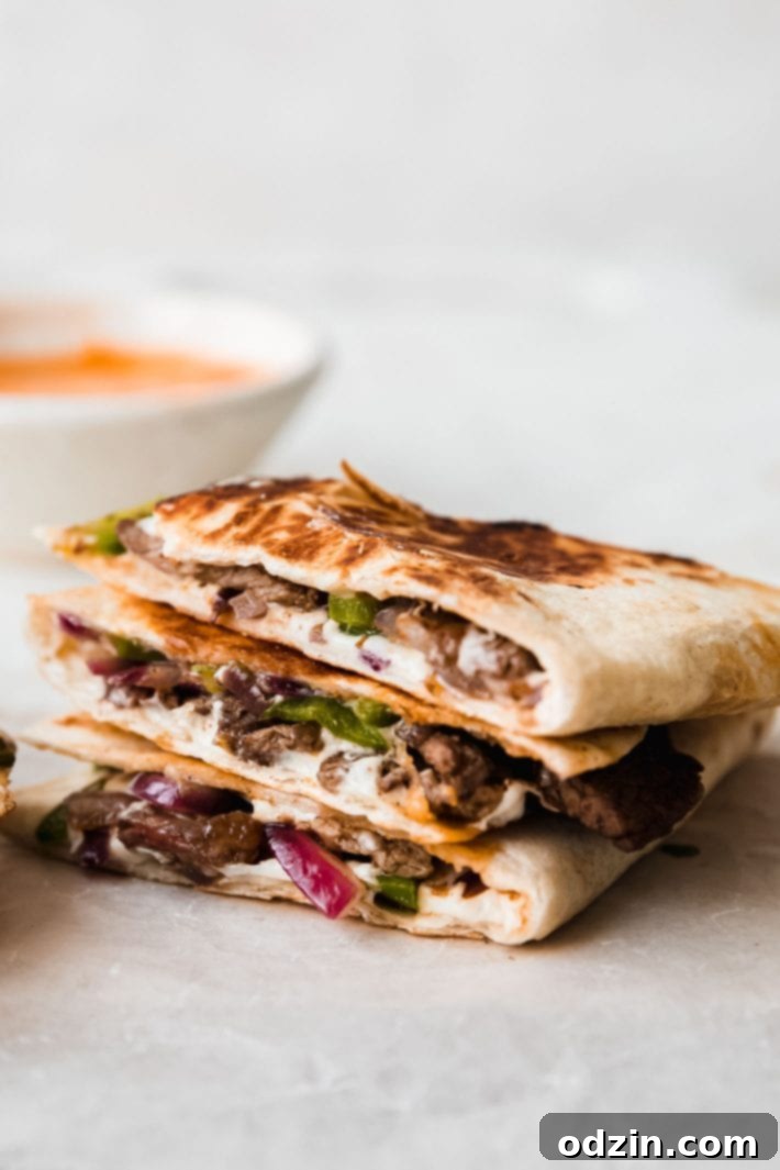 Chipotle Philly Cheesesteak Quesadillas 7 quesadillas on parchment with chipotle vinaigrette