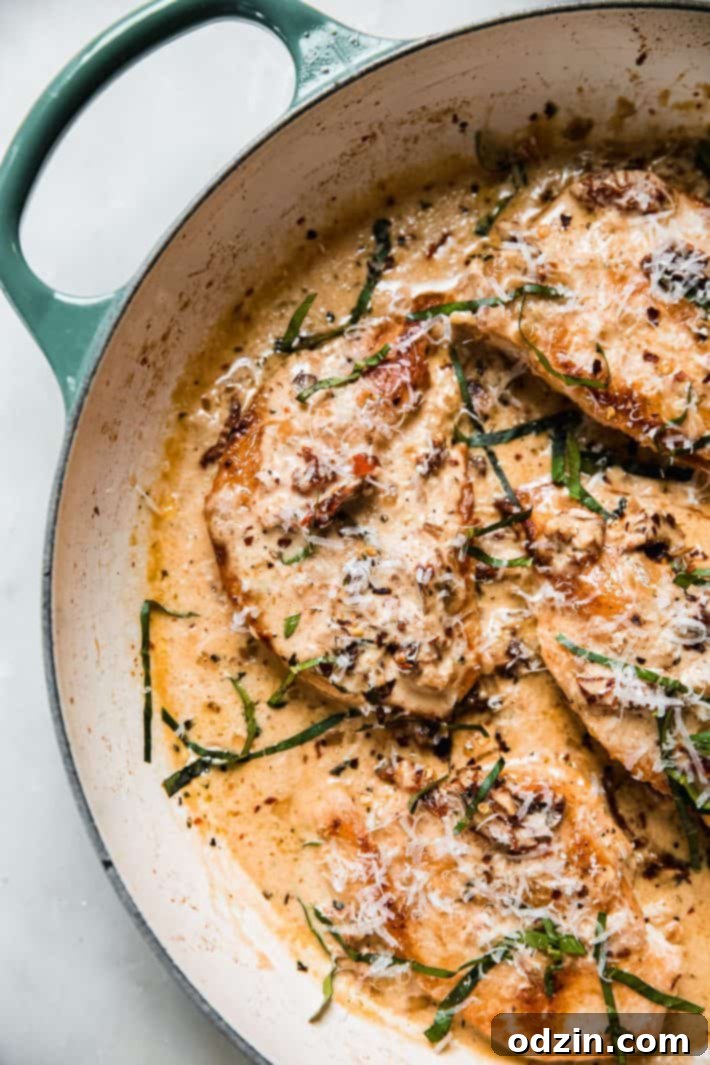 The Ultimate Marry Me Chicken Recipe 6 Another view of Marry Me Chicken simmering in a skillet, showcasing the vibrant colors of the sauce and fresh basil.