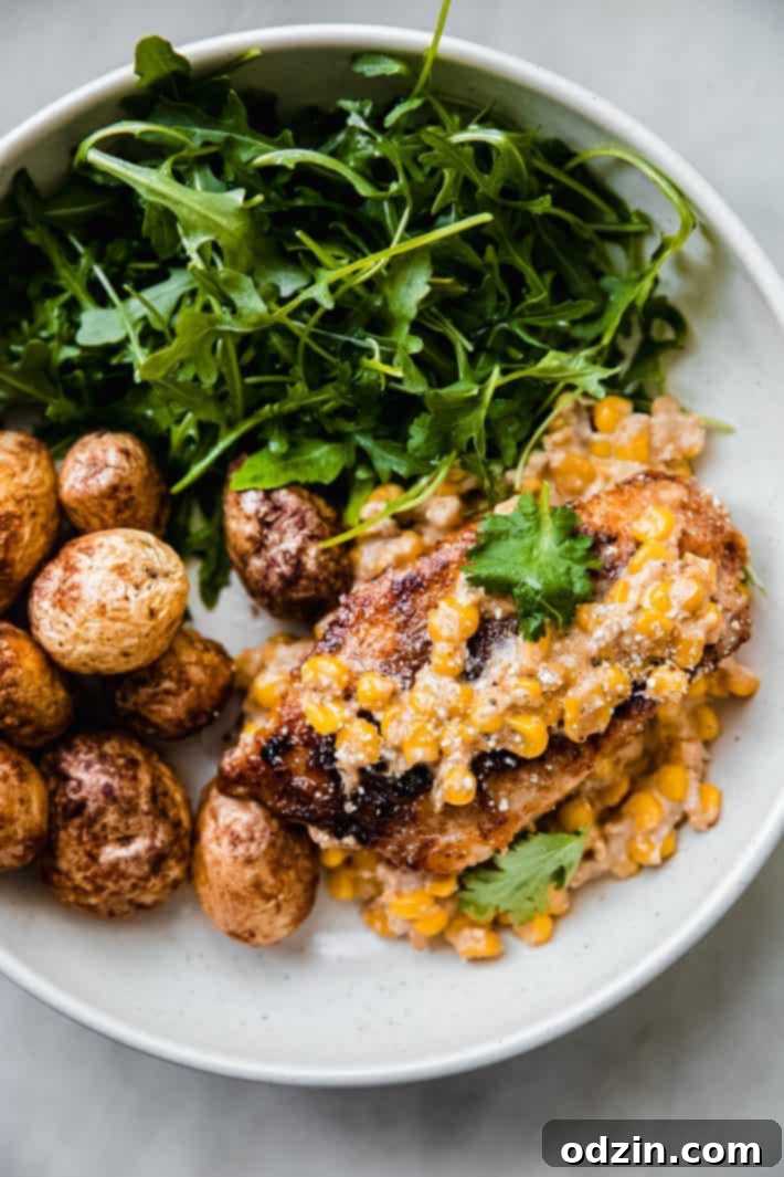fiesta creamy corn chicken served in bowls with roasted potatoes and arugula