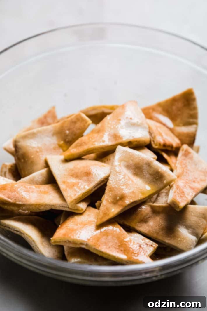 pita bread wedges in bowl tossed with oil and salt