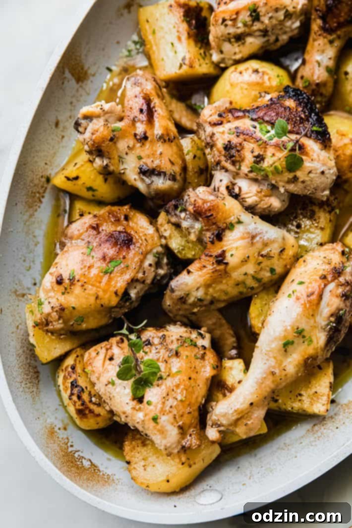 roasted chicken pieces in pan over lemon potatoes