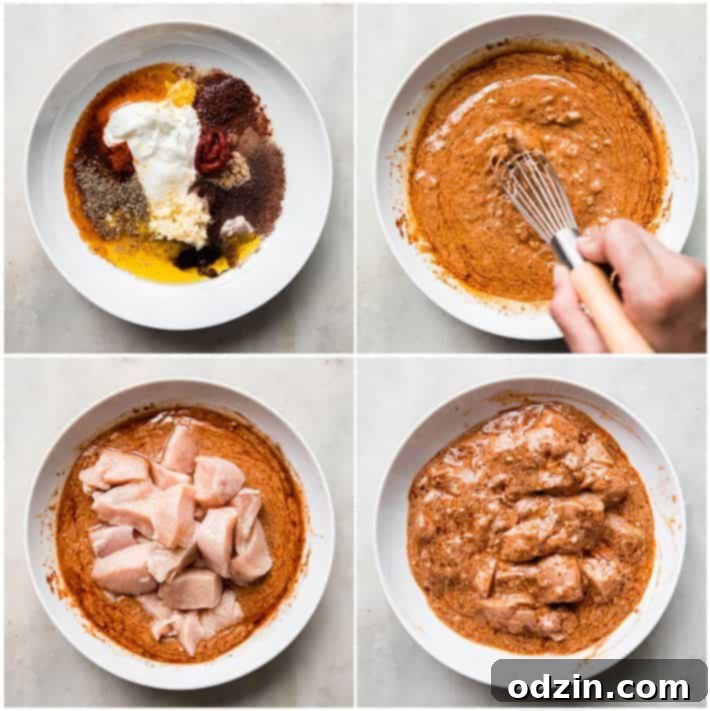 Close-up shot of chicken pieces marinating in a vibrant red Shish Tawook sauce in a glass bowl