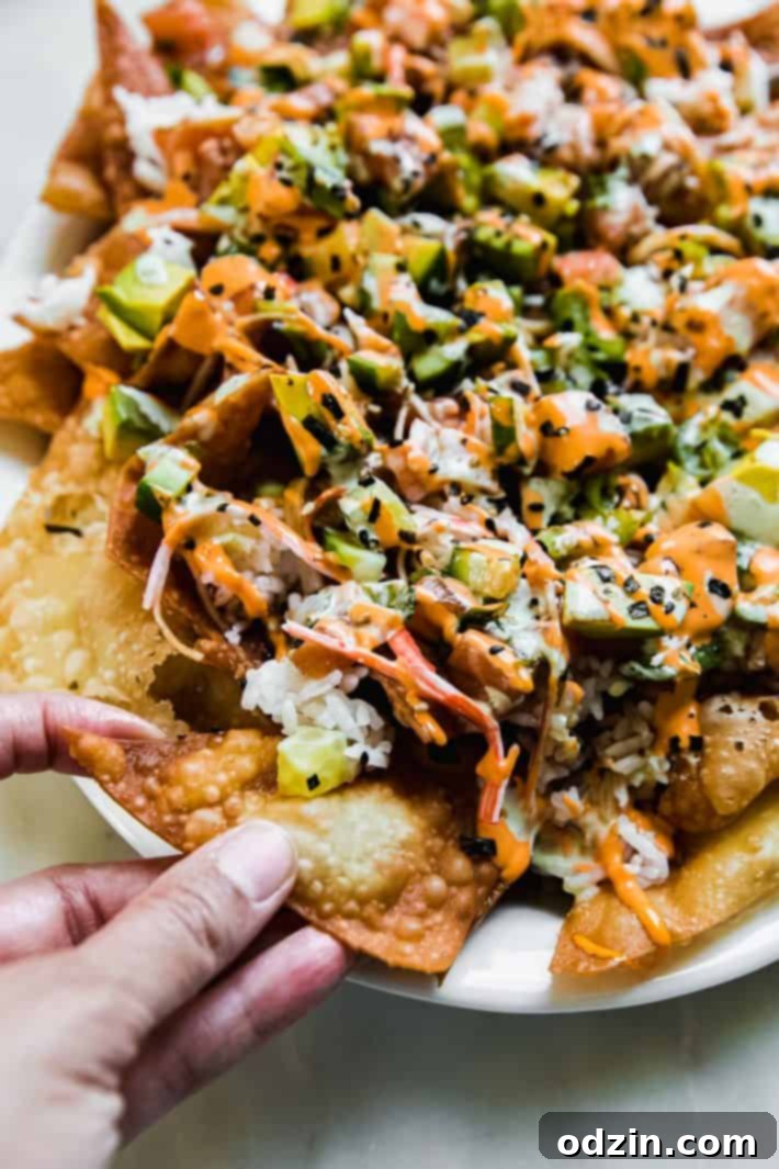 Spicy California Sushi Wonton Nachos 3 hand grabbing wonton chip with sushi nachos