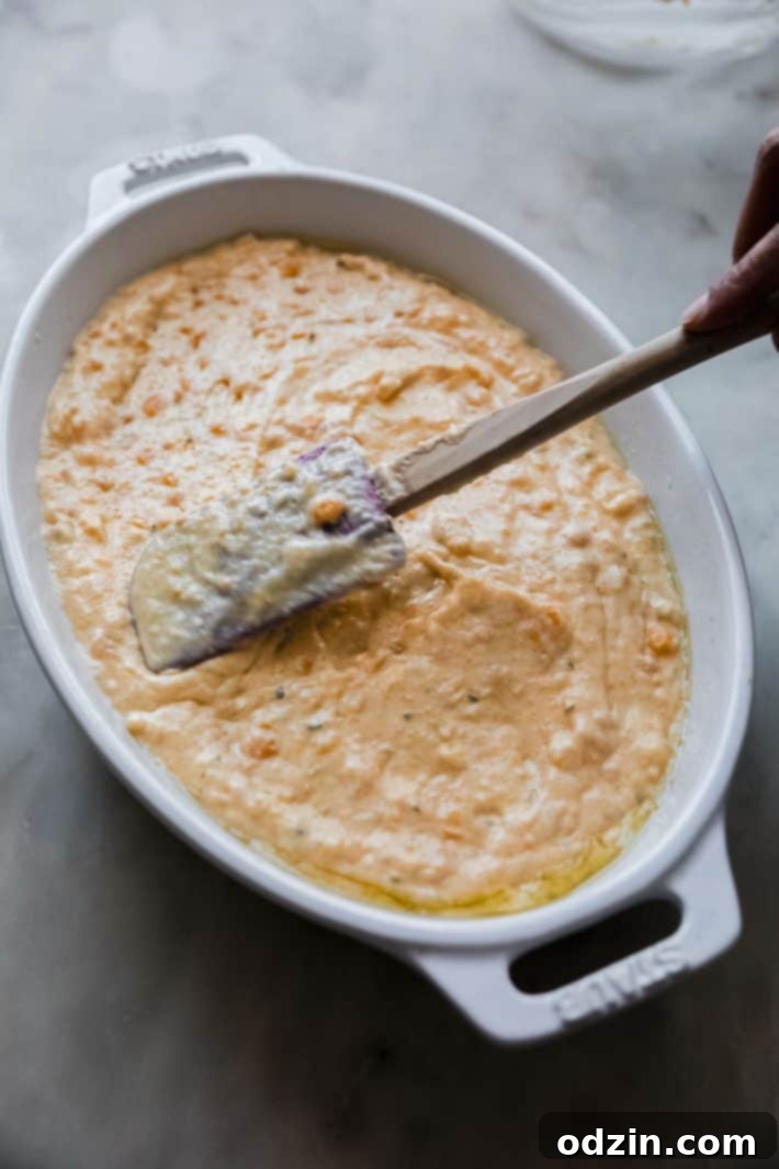 A serving of the Boursin Jiffy Corn Casserole on a plate, alongside other Thanksgiving-style dishes, ready for a feast.