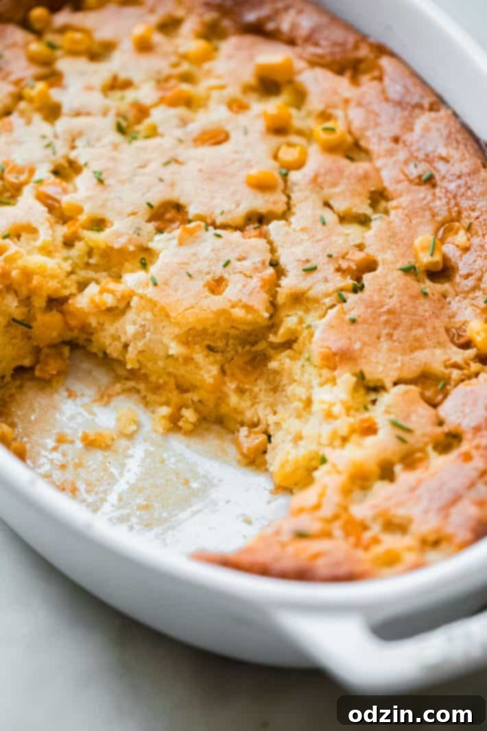 Close-up of a serving of the creamy Boursin Jiffy Corn Casserole, garnished with fresh chives.