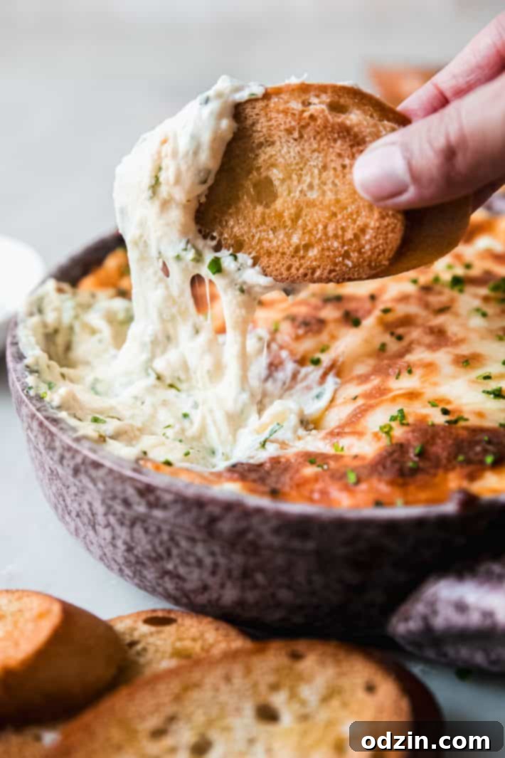 bread being dipped into garlic bread dip with cheese pull