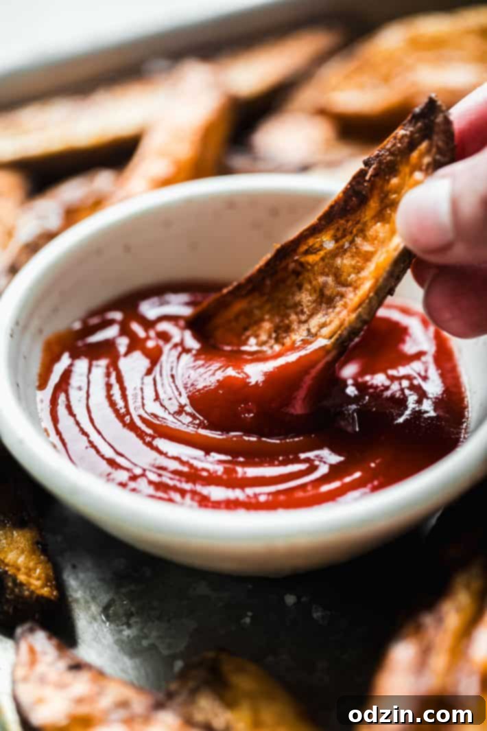 Crispy Air Fryer Potato Wedges 3 potato wedges dipped in ketchup