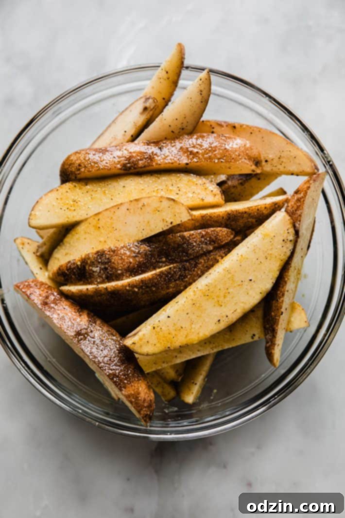 Crispy Air Fryer Potato Wedges 4 seasoned sliced wedges in bowl