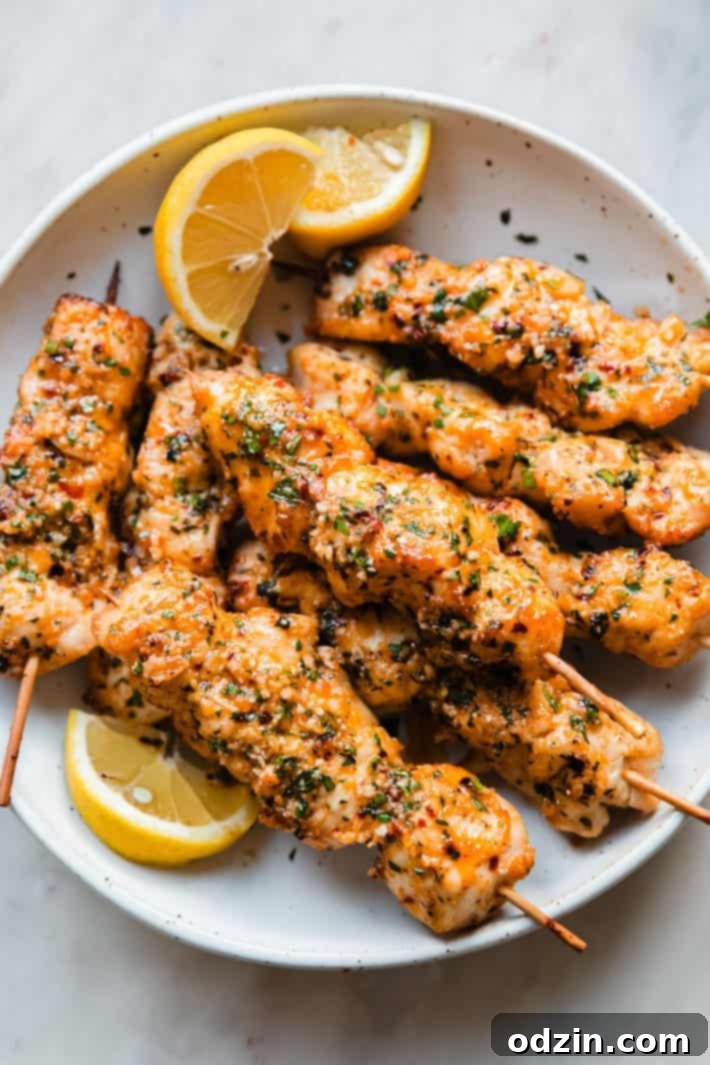 Golden Garlic Parmesan Chicken Skewers 6 plate of skewers with lemon wedges