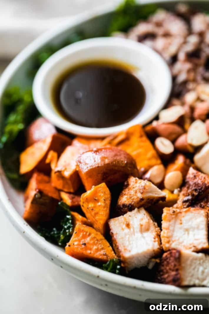 Close-up shot of roasted sweet potatoes and blackened chicken arranged beautifully in a harvest bowl