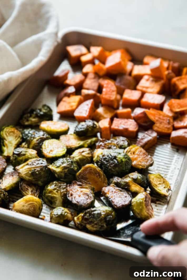 Sheet pan filled with balsamic-glazed roasted Brussels sprouts and sweet potatoes