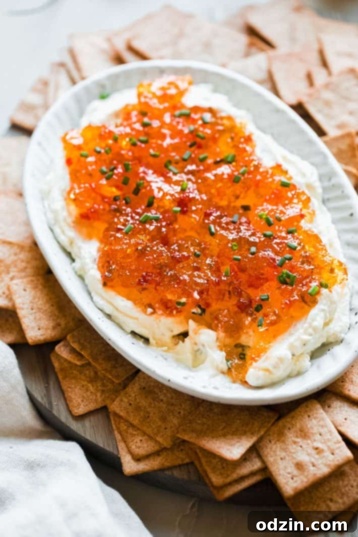 Quick and Easy Pepper Jelly Cheese Dip 2 pepper jelly cream cheese dip in platter with wheat thins