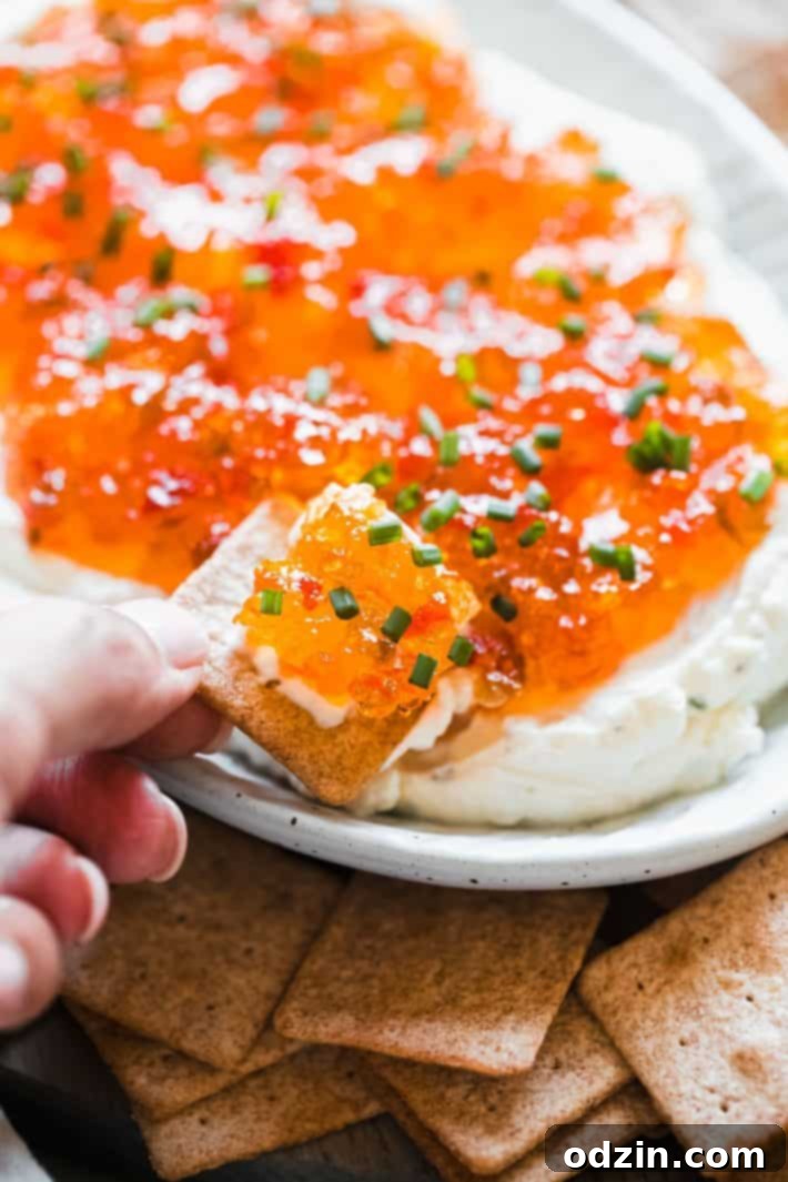 Quick and Easy Pepper Jelly Cheese Dip 3 cracker with cream cheese and pepper jelly