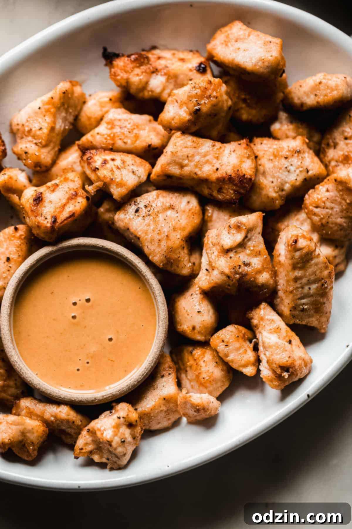 air fryer chicken bites on plate with spicy honey mustard