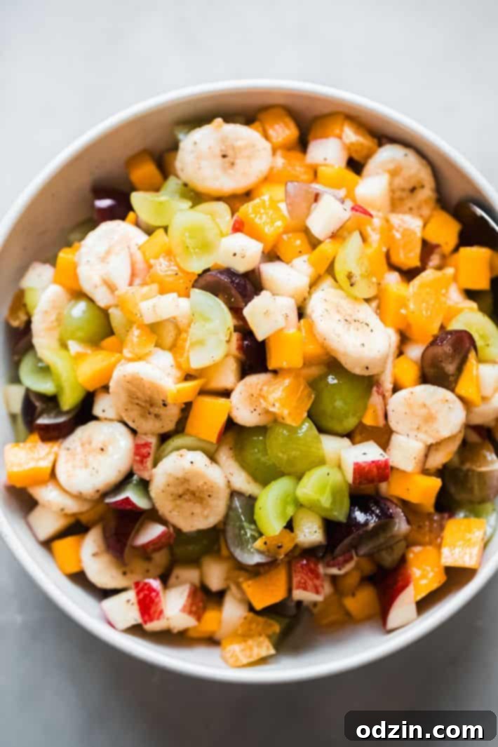 bananas, apples, grapes, tangerines, and mangoes in a fruit salad