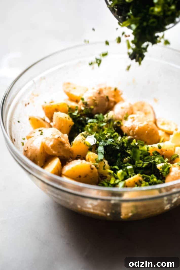 herbs sprinkling into bowl with boiled potatoes