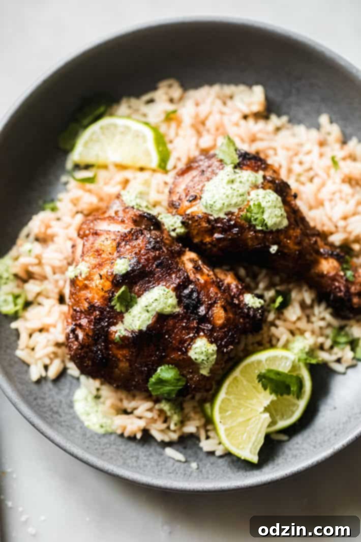 Peruvian Aji Verde Sauce 3 Peruvian green sauce generously drizzled over a plate of Pollo a la Brasa and rice, highlighting its vibrant color and rich consistency.