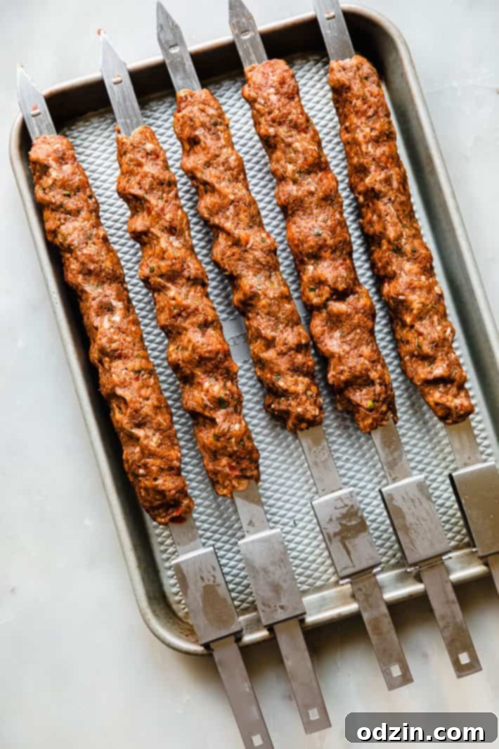 Adana Kebab skewers before grilling on baking sheet