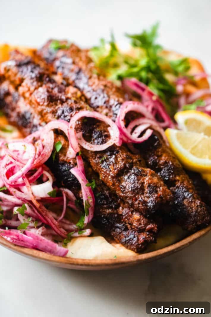 grilled kebabs topped with onion salad on flatbread with lemon and parsley