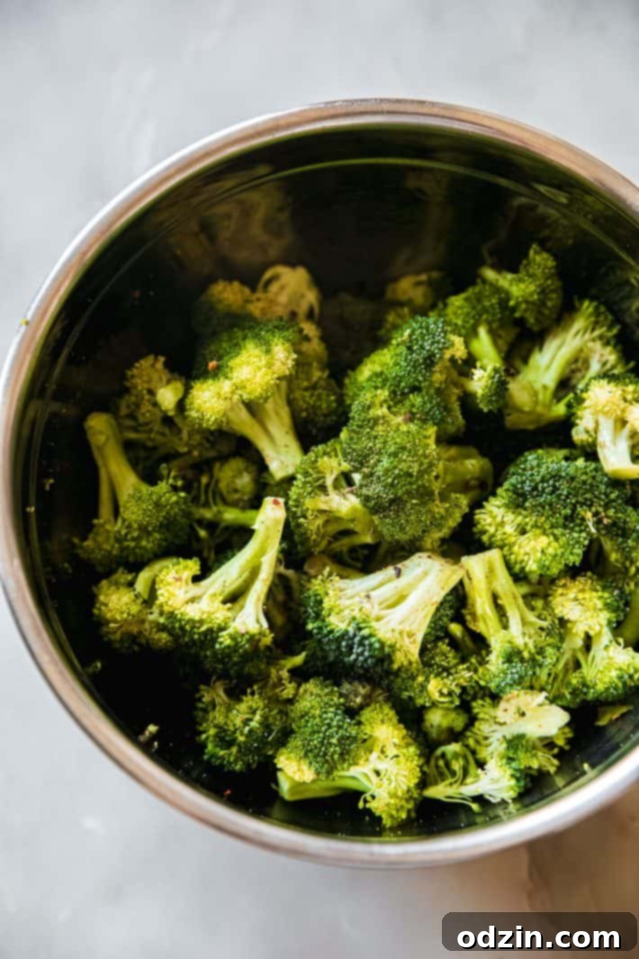 seasoned broccoli in metal bowl