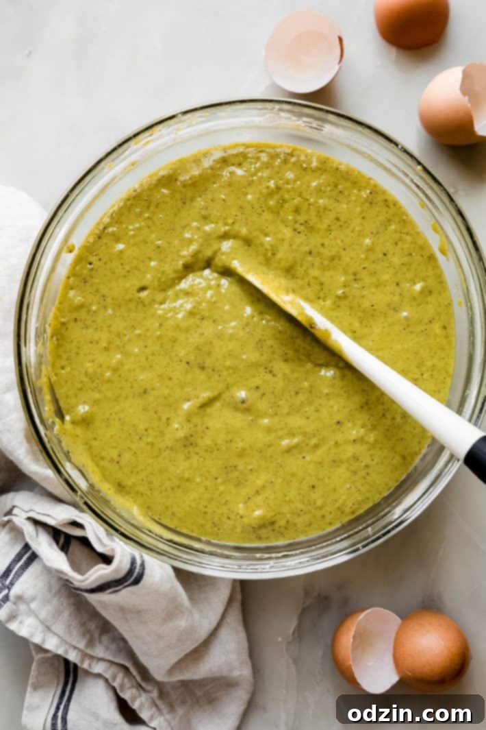 Perfectly Pistachio Muffins: Bakery Quality, Pudding-Free 4 Close-up of a bowl filled with light green pistachio muffin batter, ready to be scooped into muffin tins.